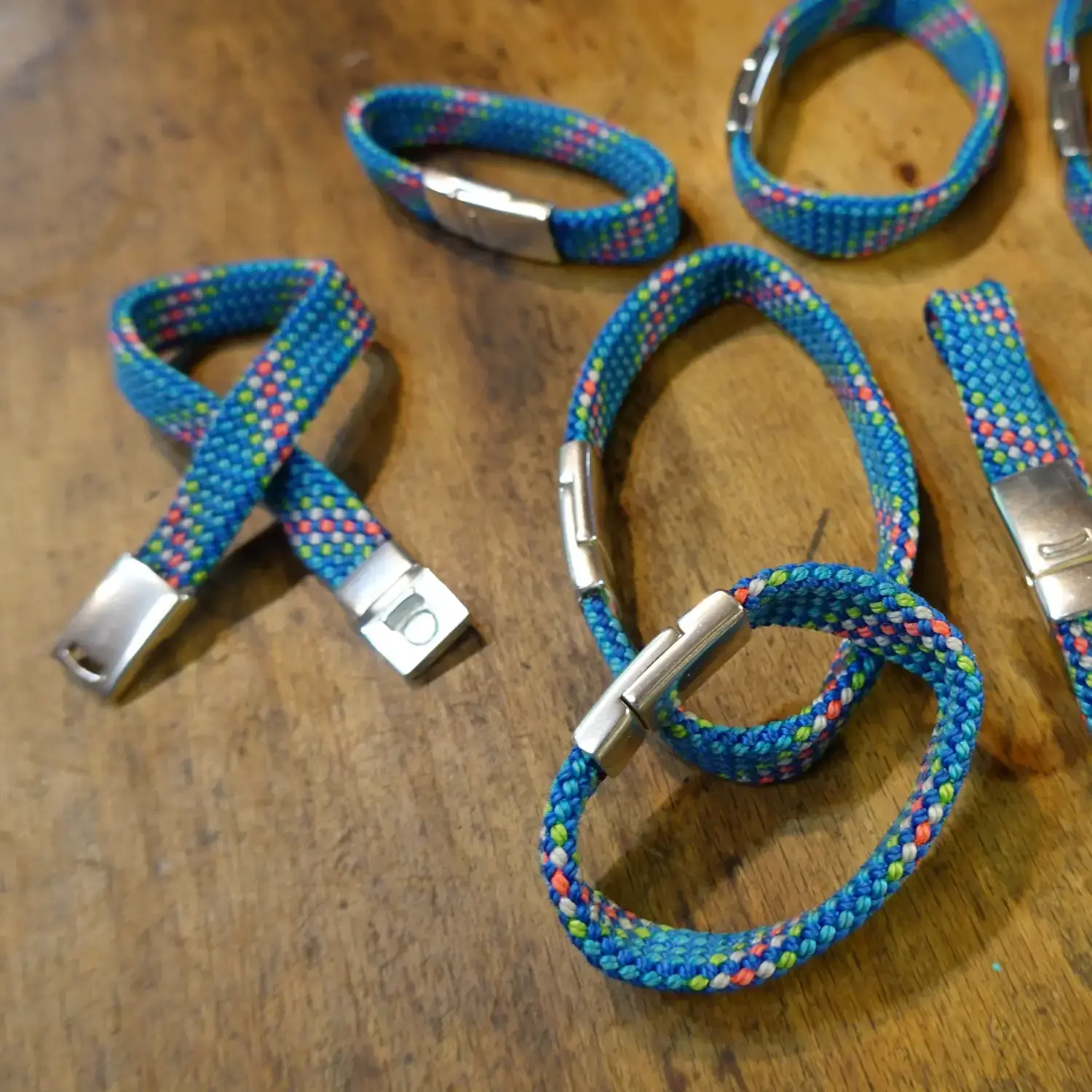 Bracelet en corde d’escalade 🧗♀️ upcyclée - Fermoir magnétique - Taille au choix Bracelets en corde d'escalade upcyclée avec fermoir magnétique - différentes tailles étalées sur du bois