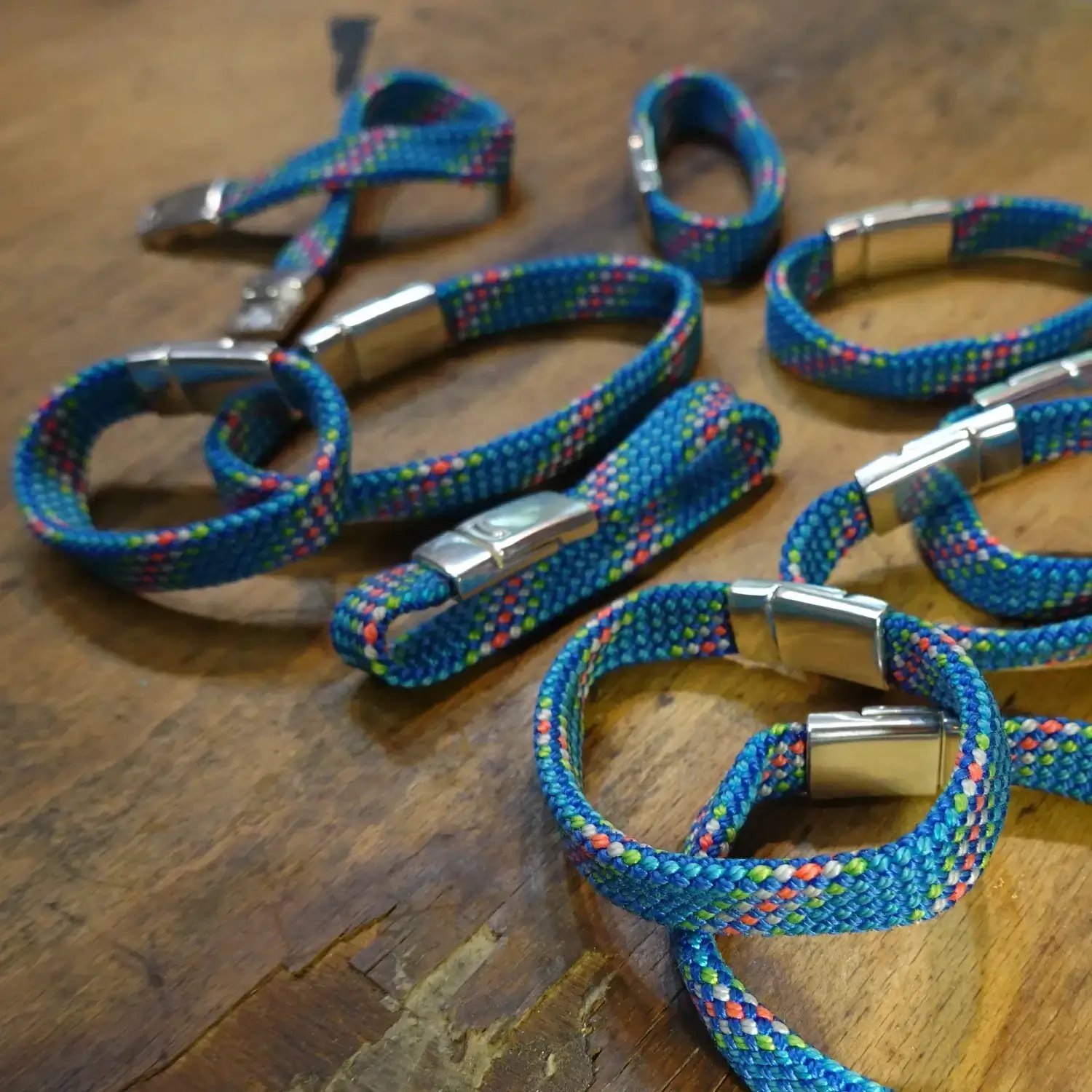Bracelet en corde d’escalade 🧗♀️ upcyclée - Fermoir magnétique - Taille au choix Bracelets en corde d'escalade upcyclée avec fermoir magnétique - différentes tailles étalées sur du bois