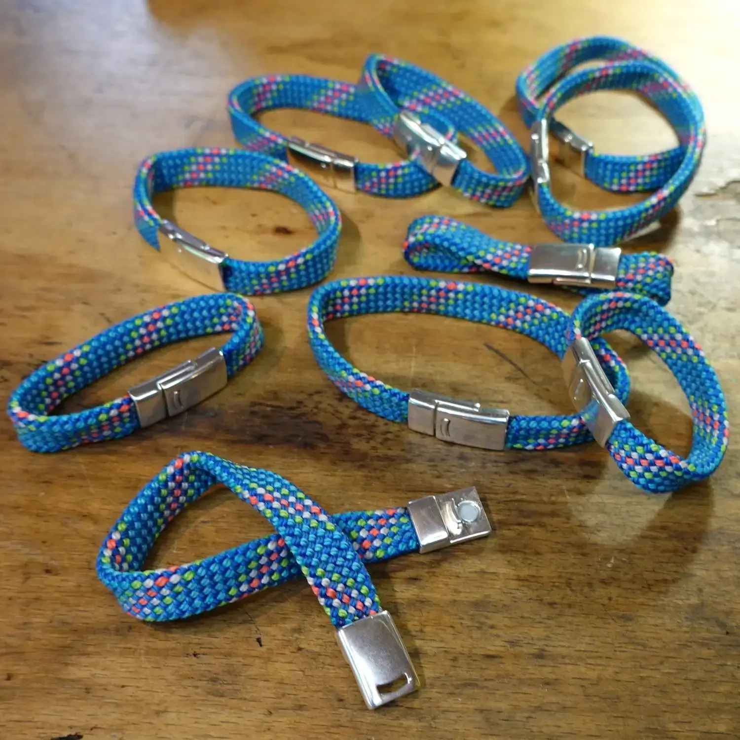 Bracelet en corde d’escalade 🧗♀️ upcyclée - Fermoir magnétique - Taille au choix Bracelets en corde d'escalade upcyclée avec fermoir magnétique - différentes tailles étalées sur du bois